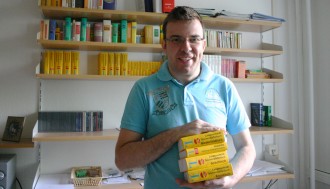 Michal Perlinski mit verschiedenen Wörterbüchern in seinem Wohnheimzimmer.